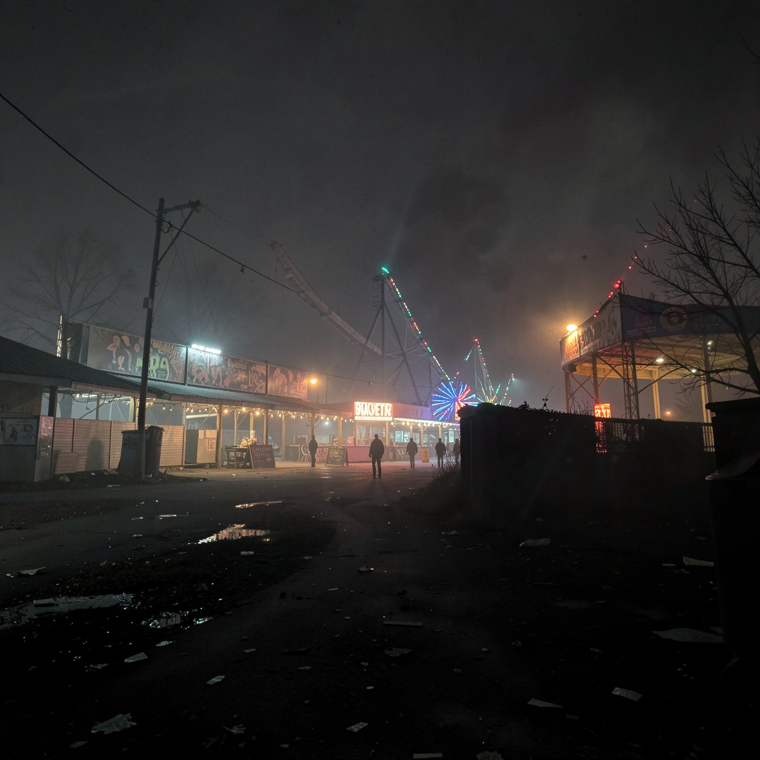 abandoned amusement park at night with fog and broken lights