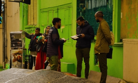 Green, Coat, Standing, Social Group, Event, Urban Area